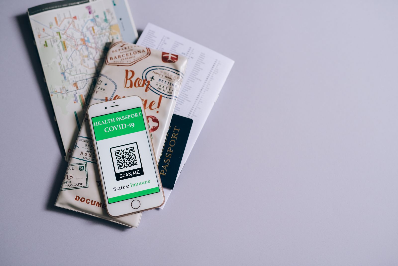 Pasaporte apoyado sobre un mapa del mundo junto a documentos de viaje