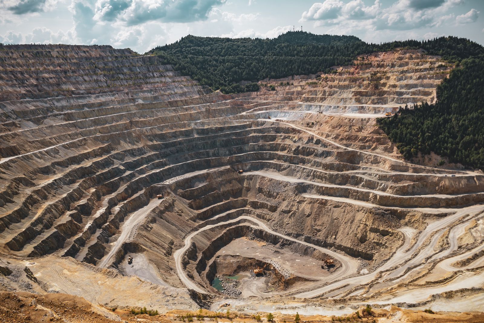 Mina de cobre a cielo abierto con maquinaria y camiones mineros en operación