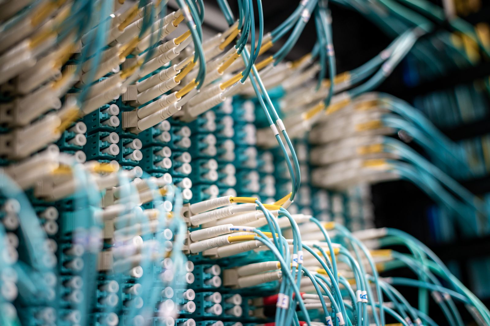 Infraestructura de red de telecomunicaciones con cableado de fibra óptica y equipos de datos.