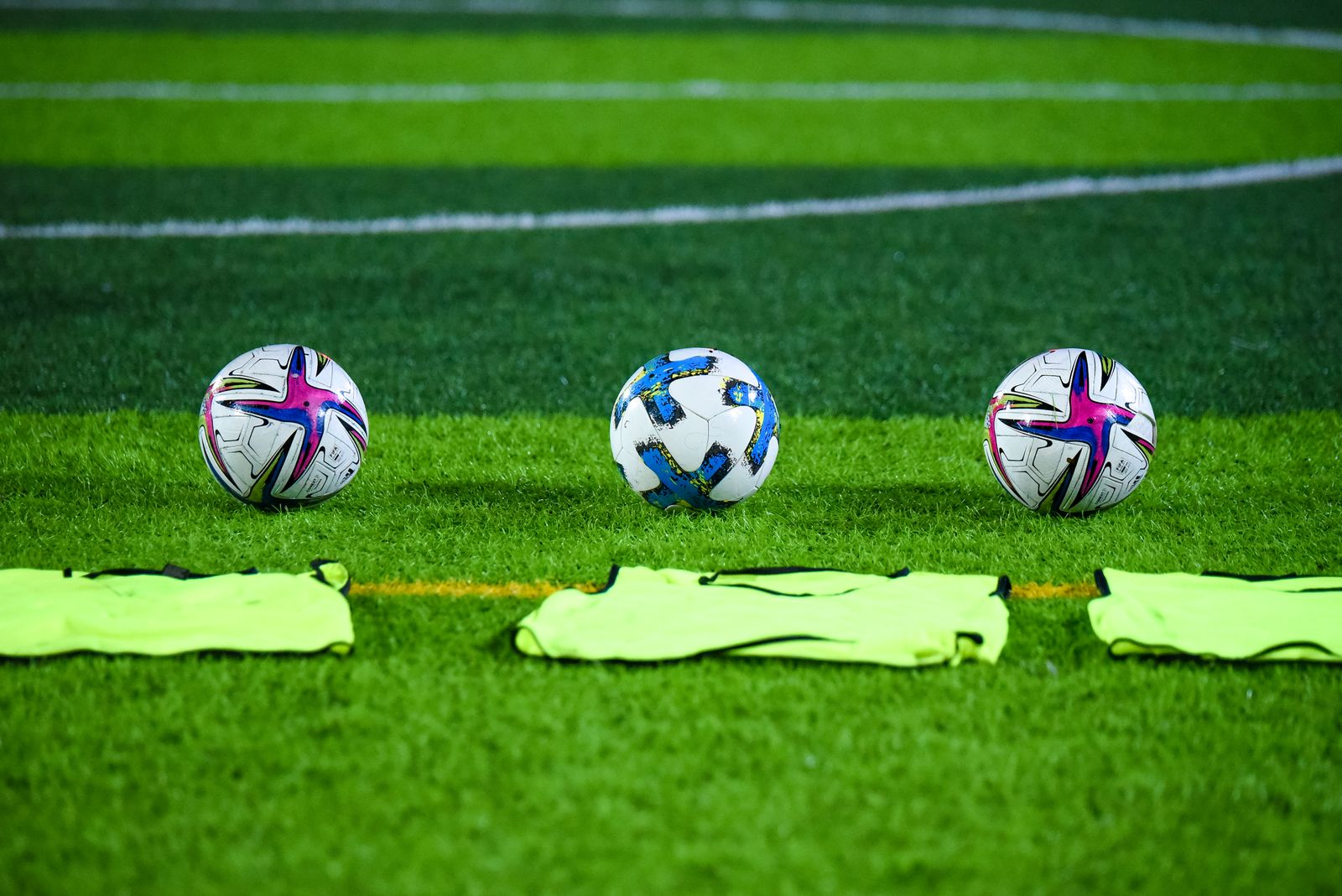 Balón de fútbol sobre el césped de un estadio con gradas al fondo